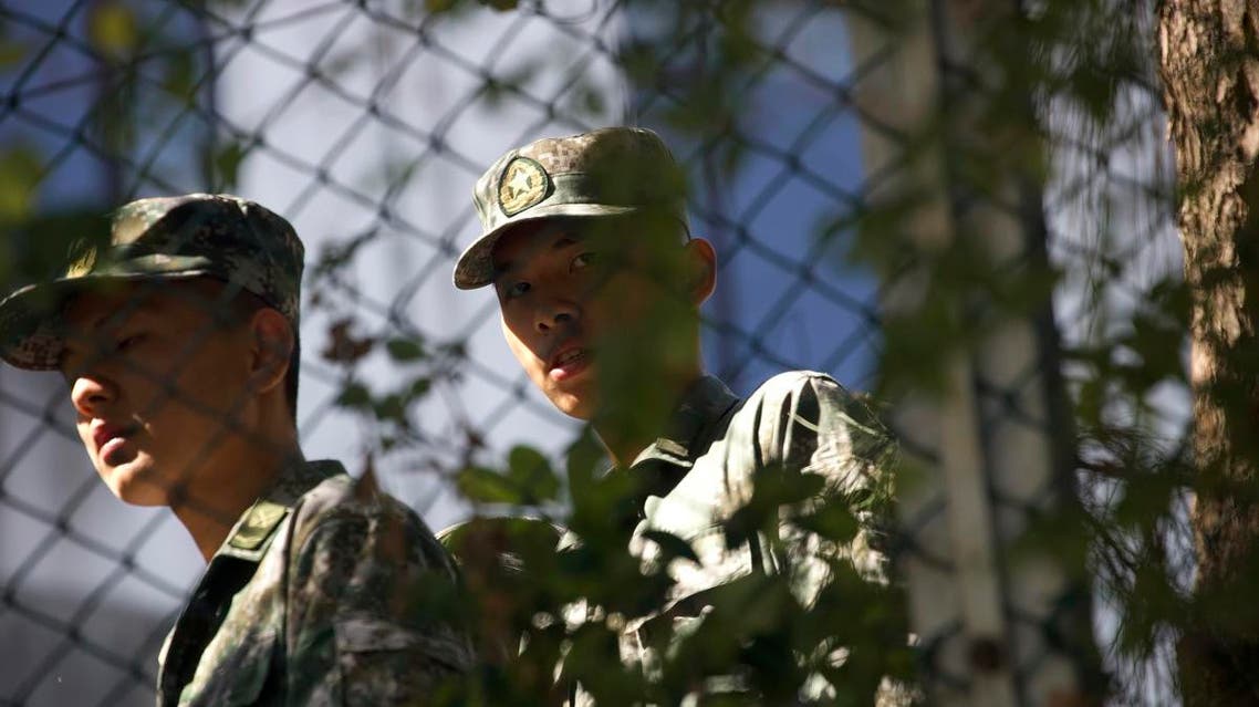 Soldiers from China's People's Liberation Army (PLA) watch a confrontation between police and protestors at the Hong Kong Polytechnic University from inside a nearby PLA garrison in Hong Kong, Sunday, Nov. 17, 2019. (AP)