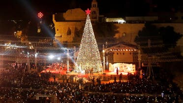 Palestinians light Christmas tree in Manger Square outside the Church of the Nativity in Bethlehem in the Israeli-occupied West Bank. (Reuters)
