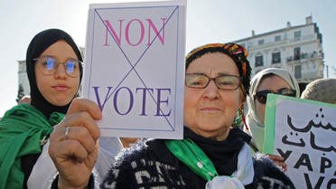 An Algerian demonstrator holds a placard that reads "no vote" during a protest against the government and the upcoming presidential elections in Algiers, Algeria, Friday, Nov.29, 2019. (AP)