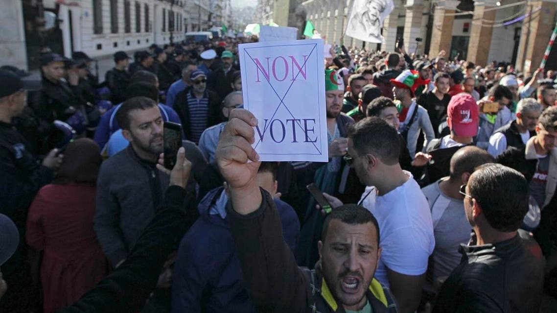An Algerian demonstrator holds a placard that reads "no vote" during a protest against the government and the upcoming presidential elections in Algiers, Algeria, Friday, Nov.29, 2019. (AP)