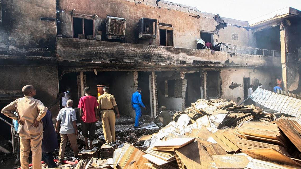 Members of the Sudanese Civil Defence search for victims at the scene of a fire at a tile manufacturing unit in an industrial zone in north Khartoum, on December 3, 2019. (AFP)