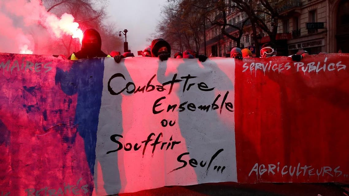 Protesters hold a banner during a demonstration against French government's pensions reform plans in Paris as part of a day of national strike and protests in France, December 5, 2019. The slogan reads "Fight together or suffer alone". (Photo: Reuters)