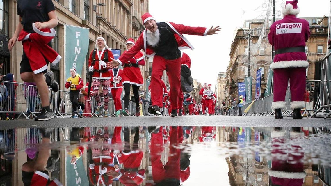 Participants run in Glasgow's annual Christmas Santa dash through the city center, in Glasgow, Scotland. (AP)