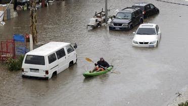 A Lebanese man uses a canoe as means of transportation on a flooded road due to heavy rain, at the southern entrance of the capital Beirut on December 9, 2019. (AFP)