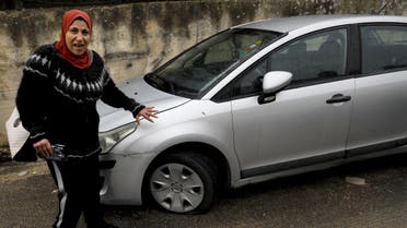 A Palestinian women displays her vehicle's slashed tire in the Palestinian neighbourhood of Shuafat, neighbouring the Israeli settlement of Ramat Shlomo, in Israeli annexed east Jerusalem, on December 9, 2019. (AFP)