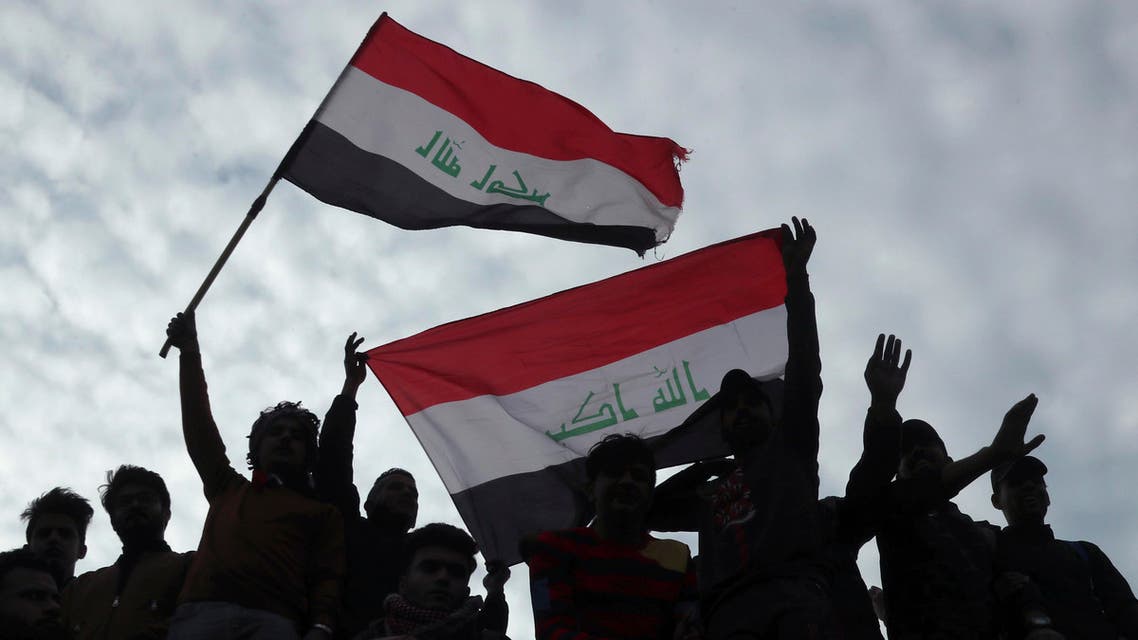 Protesters chant anti government slogans and fly Iraqi flags during minor clashes with Iraqi riot police, at a bridge in Baghdad, Iraq, Tuesday, Dec. 10, 2019. (AP)