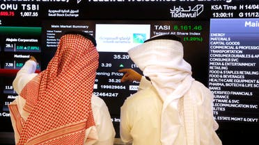 Saudi stock market officials watch the market screen displaying Saudi Arabia's state-owned oil company Aramco after the debut of Aramco's initial public offering (IPO) on the Riyadh's stock market in Riyadh, Saudi Arabia, Wednesday, Dec. 11, 2019. (AP Photo/Amr Nabil)