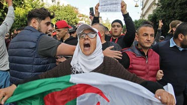 An Algerian woman chants slogans as she waves a national flag while taking part in an anti-government demonstration in the capital Algiers on December 12, 2019 (AFP)