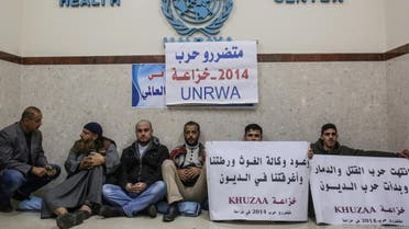 Palestinian protesters hold placards calling on the United Nations Relief and Works Agency (UNRWA) to pay them for the repair of their homes, damaged during the 2014 Israel–Gaza conflict. (AFP)