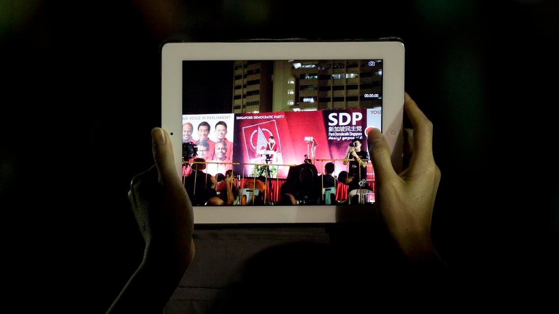 A supporter records the final rally for the opposition Singapore Democratic Party ahead of the Sept. 11 general elections in Singapore. (File photo: AFP)