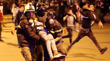 Civil defense workers carry an injured protester after a clash with riot police, during an anti-government protest near the parliament square in downtown Beirut, Lebanon, Saturday, Dec. 14, 2019. (AP)