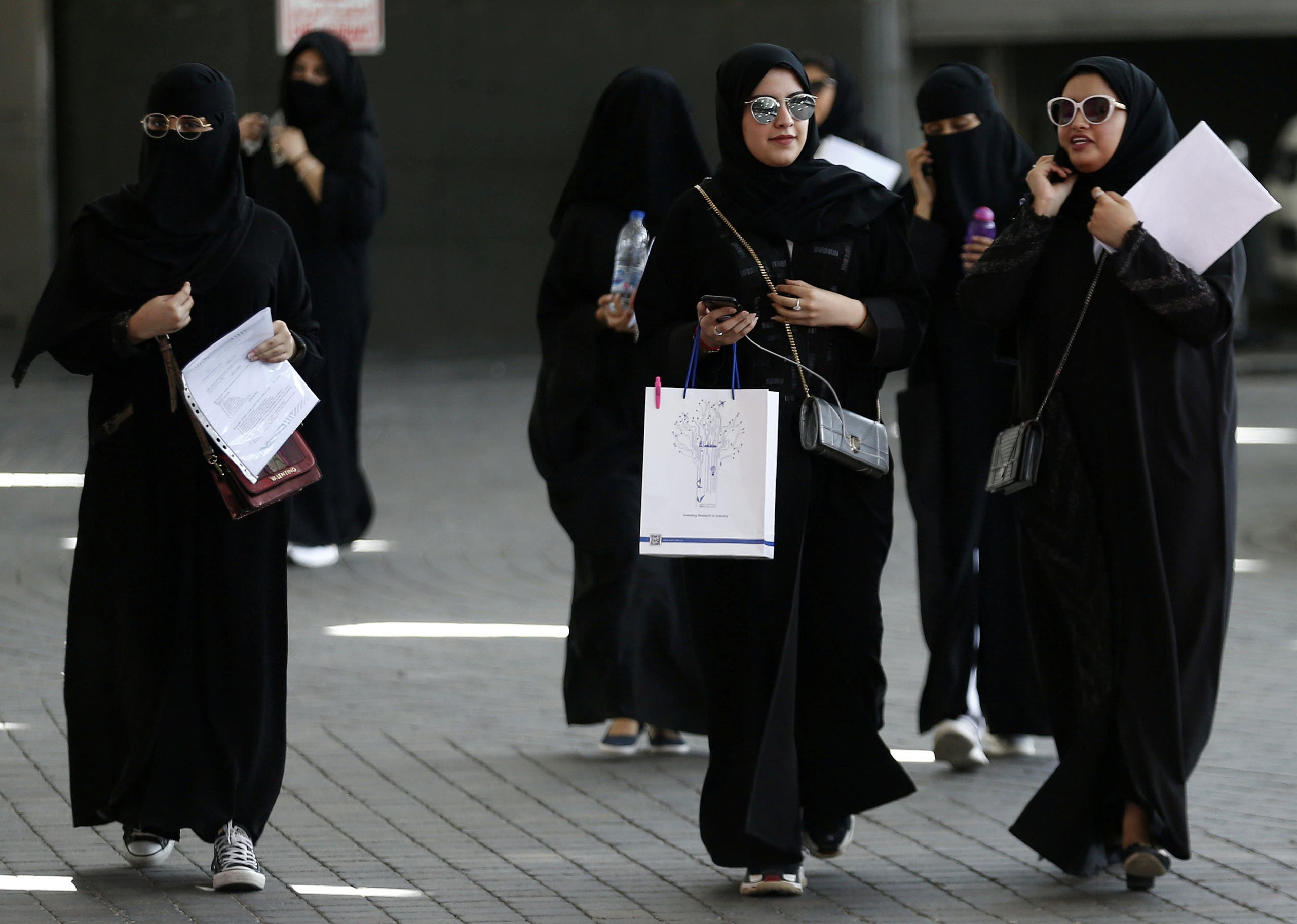 Saudi students walk at the exhibition to guide job seekers. (File photo: Reuters)