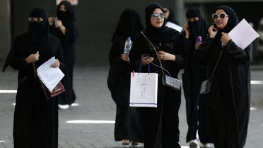 Saudi students walk at the exhibition to guide job seekers. reuters