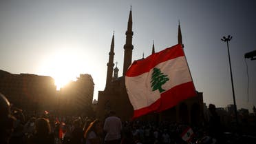 Lebanese demonstrators wave national flags as they take part in a protest in the capital Beirut, outside the Mohammad al-Amin mosque in the downtown district's Martyr's Square on October 19, 2019. Tens of thousands of Lebanese people took to the streets today for a third day of protests against tax increases and alleged official corruption despite several arrests by security forces.