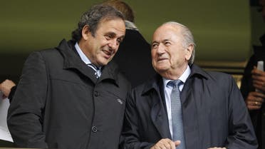 Michel Platini (L) and Jpseph “Sepp” Blatter (R) talk before a match at Stamford Bridge in London on May 23, 2013. (File photo: AFP)