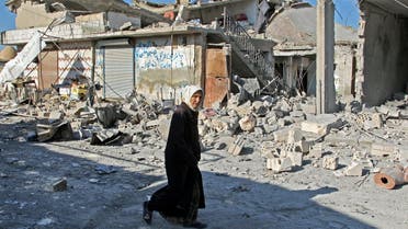 A Syrian woman walks past destruction at the site of a reported government bombardment in the village of Maasaran on the outskirts of Maaret al-Numan in Syria's northwestern Idlib province on December 17, 2019. Abdulaziz KETAZ / AFP