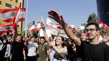 Lebanese students from various schools wave national flags and shout slogans as they gather in front of the Ministry of Education. (File photo: AFP)