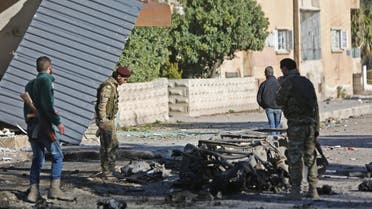 Turkish-backed Syrian fighters stand at the scene of a car bomb explosion in the centre of the town of Ras al-Ain, along the border with Turkey in the northeastern Hassakeh province, on December 4, 2019. Nazeer Al-khatib / AFP