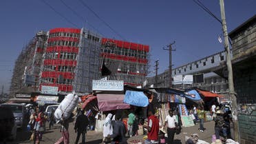 A new shopping centre under construction is seen behind old buildings and market stalls at the Mercato market in Addis Ababa November 18, 2015. Addis Ababa's 'Mercato' - Italian for 'market' - is reputedly the biggest open-air market in Africa, lying in the west of the capital. Supermarkets have sprouted across the city as the metropolis has expanded with Ethiopia's booming economy, but Mercato remains a popular destination for shoppers seeking clothing, electronics and a huge range of other items. It has been around for as long as the city, which was founded at the end of the 19th century, but it took its current form, and its name, from the Italians who invaded Ethiopia in 1935. The Italian occupation ended in 1941. Picture taken November 18, 2015. REUTERS/Tiksa Negeri