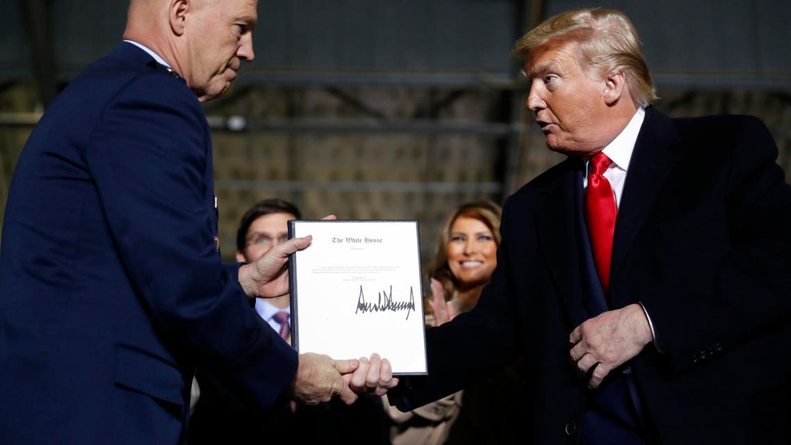 President Donald Trump shakes hands with Gen. Jay Raymond, after signing the letter of his appointment as the chief of space operations for U.S. Space Command during a signing ceremony for the National Defense Authorization Act for Fiscal Year 2020 at Andrews Air Force Base, Md., Friday, Dec. 20, 2019. (AP Photo/Andrew Harnik)