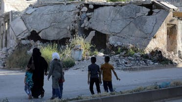People walk near rubble of damaged buildings in the city of Idlib, Syria. (Reuters)