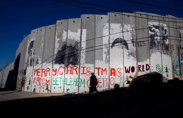 A Palestinian man walks past a portion of Israel's separation barrier in Bethlehem in December 2010. (File photo: AP)
