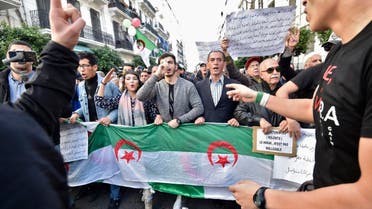 Protesters chant slogans as they march signs and Algerian national flags during an anti-government demonstration in the capital Algiers on December 24, 2019. (AFP)