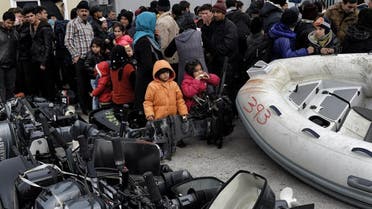 Refugees and migrants and their children wait in the northern island of Lesbos, after crossing the Aegean sea from Turkey. (File photo: AFP)