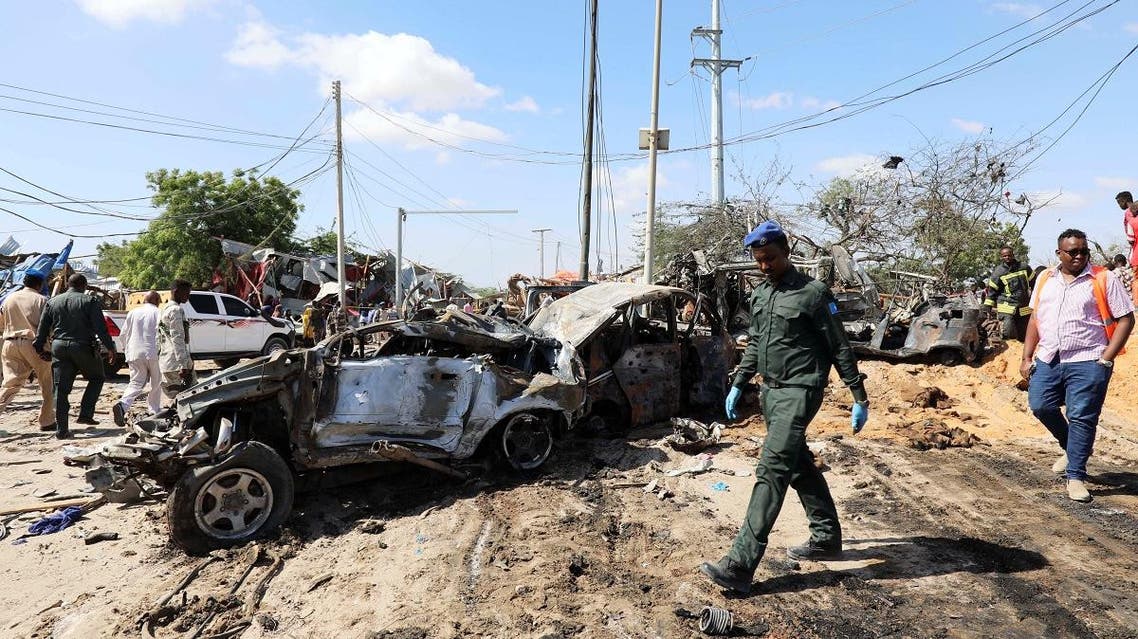 A Somali police officer walks past a wreckage at the scene of a car bomb explosion at a checkpoint in Mogadishu, Somalia, on December 28, 2019. (Reuters)