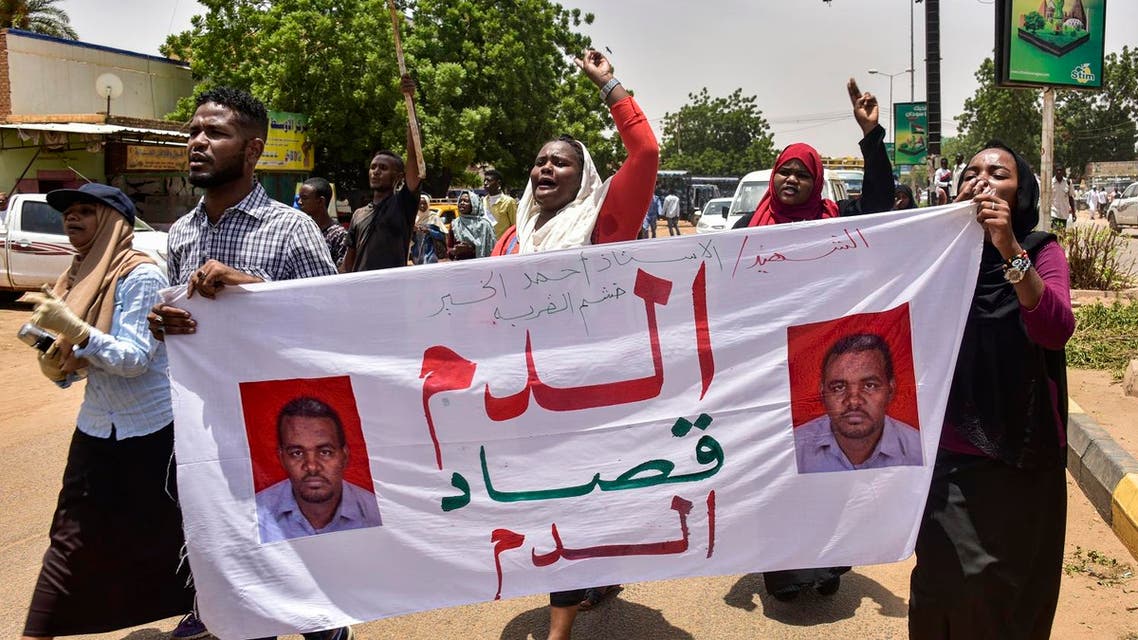 Demonstrators chant slogans as they march with a banner reading in Arabic "blood for blood" outside a courthouse complex in the Sudanese capital's twin city of Omdurman on August 21, 2019 during the trial of 40 members of Sudan's now-dissolved National Intelligence and Security Service facing charges over the death in custody of Ahmed al-Kheir, a teacher from the eastern town of Khashma el-Girba, in the early days of the wave of nationwide protests that eventually brought longtime ruler Omar al-Bashir. (photo: AFP)