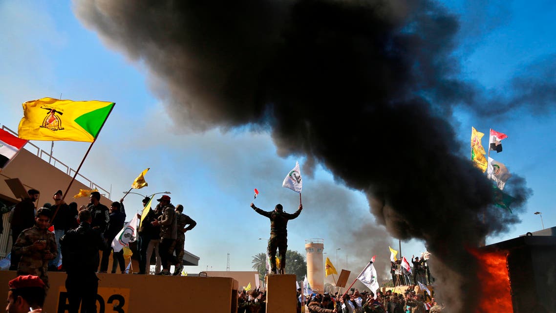 Protesters burn property in front of the U.S. embassy compound, in Baghdad, Iraq, Tuesday, Dec. 31, 2019.