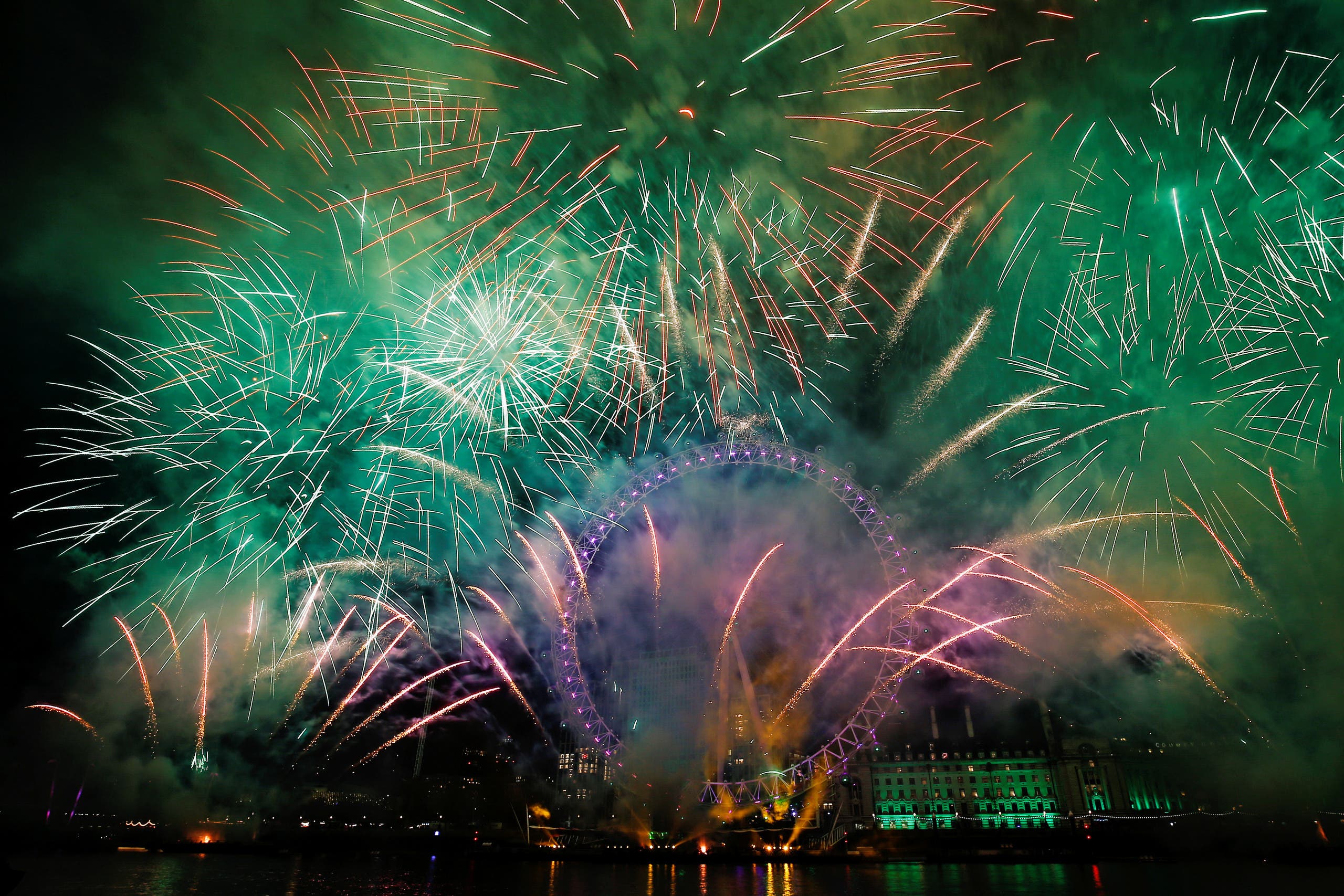 Fireworks explode over the London Eye wheel during New Year celebrations in central London (AP)