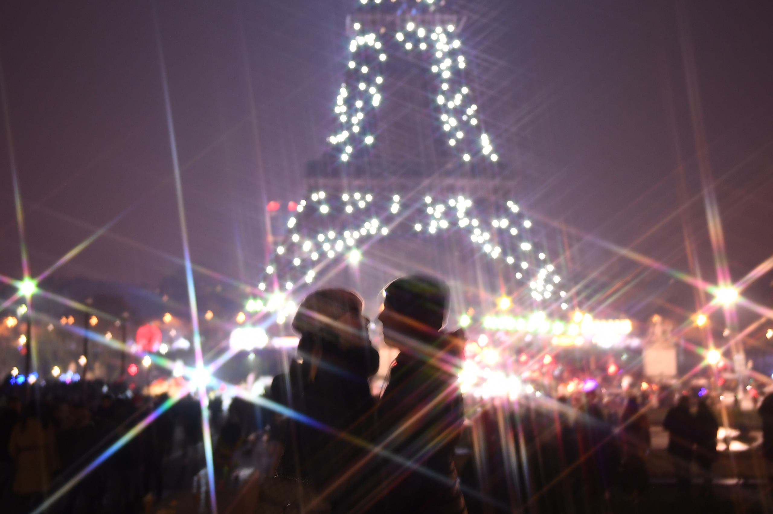 A couple in front of the Eiffel tower during the New Year's celebrations in Paris. (Photo: AFP)