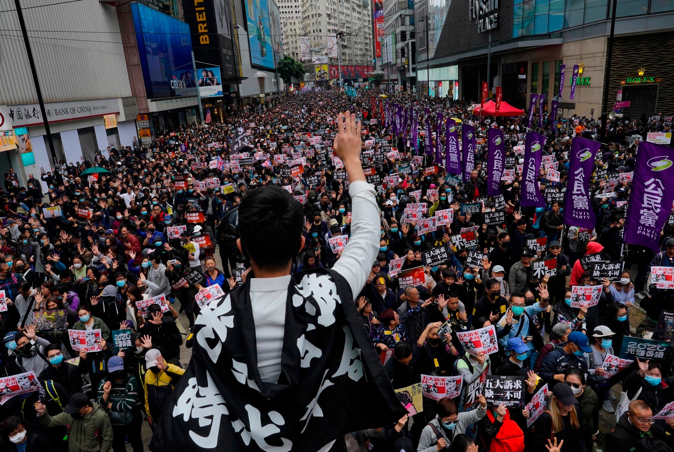 A protestor shows five demands gesture as Hong Kong people participate in their annual pro-democracy march in Hong Kong, Wednesday, Jan. 1, 2020. (AP)