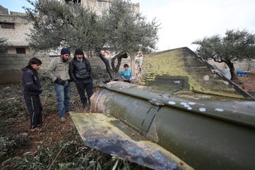 People gather around the remains of a missile, fired by Syrian regime forces. (AFP)