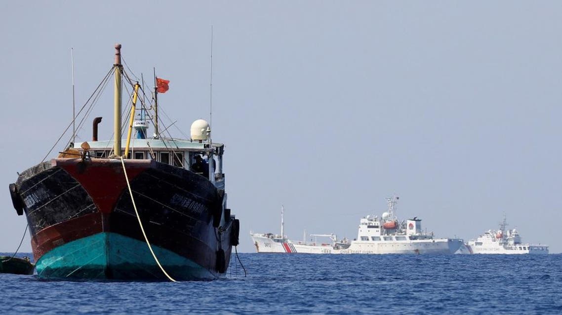 China Coast Guard vessels patrol past a Chinese fishing vessel at the disputed Scarborough Shoal. (File photo: Reuters)