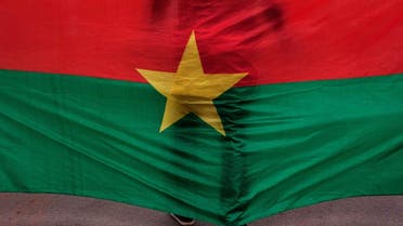 A man stand in front of the Burkina Faso nationals flag. (File photo: AP)