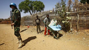 Sudanese boys push a wheelbarrow past a United Nations peace keeper at the El-Riyadh camp for internally displaced persons (IDP) in Geneina, the capital of the state of Sudan's West Darfur, on February 8, 2017. (AFP)