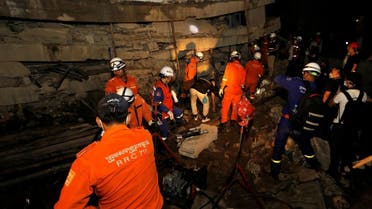 A rescue team searches for trapped workers at a collapsed building, which was under construction in Kep, Cambodia. (Reuters)