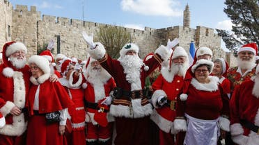 A group of some 50 people dressed in Santa Claus from various countries around the world visits the old city of Jerusalem on January 05, 2020. (AFP)