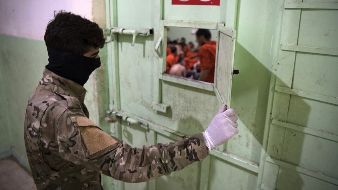 A member of the Syrian Democratic Forces (SDF) stands guard in a prison where men suspected to be afiliated with the Islamic State (IS) group are jailed in northeast Syria in the city of Hasakeh on October 26, 2019. Kurdish sources say around 12,000 IS fighters including Syrians, Iraqis as well as foreigners from 54 countries are being held in Kurdish-run prisons in northern Syria.
