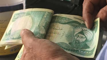 An Iraqi policeman pays for groceries with 10,000-Iraqi dinar banknotes bearing an image of Mosul's iconic leaning minaret, known as the "Hadba" (Hunchback), on June 22, 2017, in the capital Baghdad. Iraqi officials say jihadists have blown up Mosul's iconic minaret and the mosque where the Islamic State group's leader appeared in 2014 and urged Muslims to join his "caliphate". The Islamic State group (IS) says the Nuri mosque, where jihadist supremo Abu Bakr al-Baghdadi gave his first sermon as "caliph", was destroyed by a US air strike. Ali CHOUKEIR / AFP