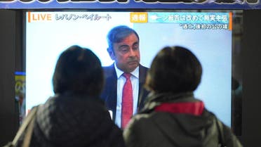 People in Tokyo watch a public TV showing a live broadcast of former Nissan chairman Carlos Ghosn speaking from Lebanon at his press conference Wednesday, Jan. 8, 2020. (AP)