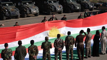 Members of the Iraqi Kurdish Peshmerga forces hold up a giant Kurdish flag to commemorate the annual Kurdish Flag Day. (File photo: AFP)