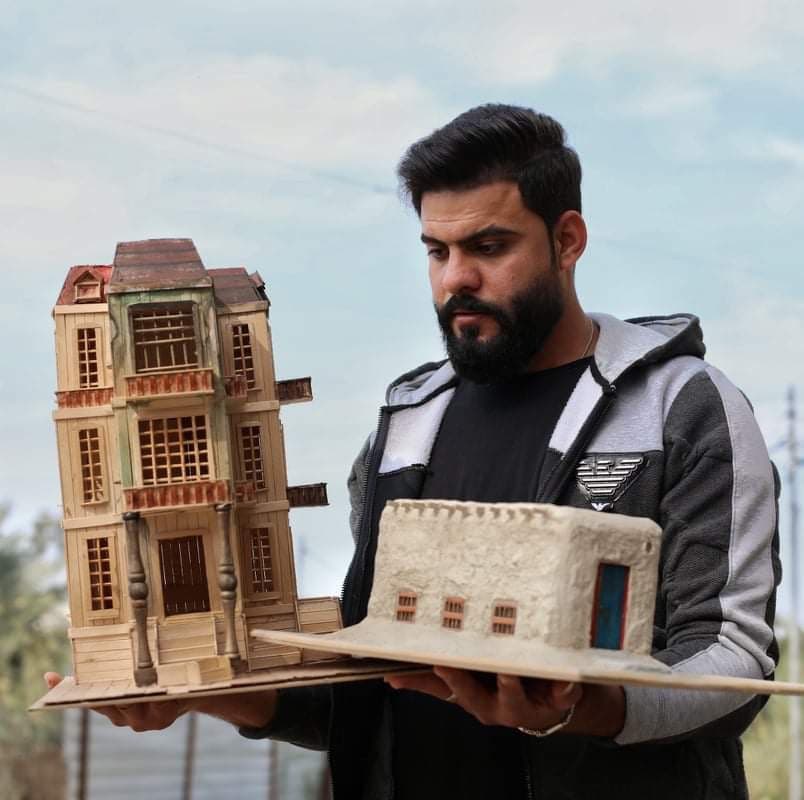 الشاب كرار محمد مع مجسمين من صنعه