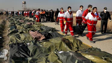 Rescue workers carry the body of a victim of a Ukrainian plane crash in Shahedshahr, southwest of the capital Tehran, Iran, Wednesday, Jan. 8, 2020. (AP)