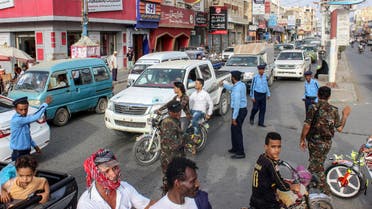 Yemeni policemen (in blue) and Huthi fighters control the traffic at the centre of the port city of Hodeidah, around 230 kilometres west of the capital Sanaa, on May 13, 2019. The United Nations said on May 12, 2019 that a Yemeni rebel withdrawal from key Red Sea ports was proceeding as planned, after the government accused the insurgents of faking the pullout.