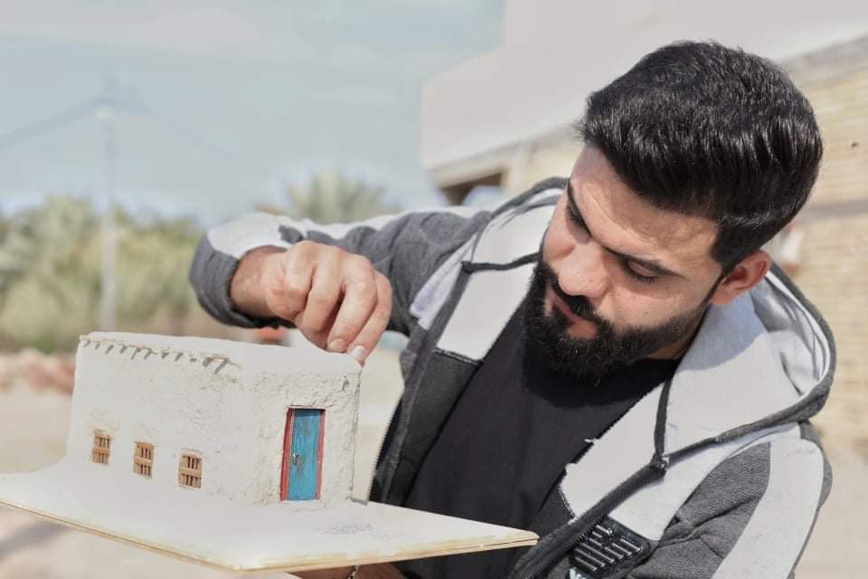 الشاب كرار محمد مع مجسم من صنعه