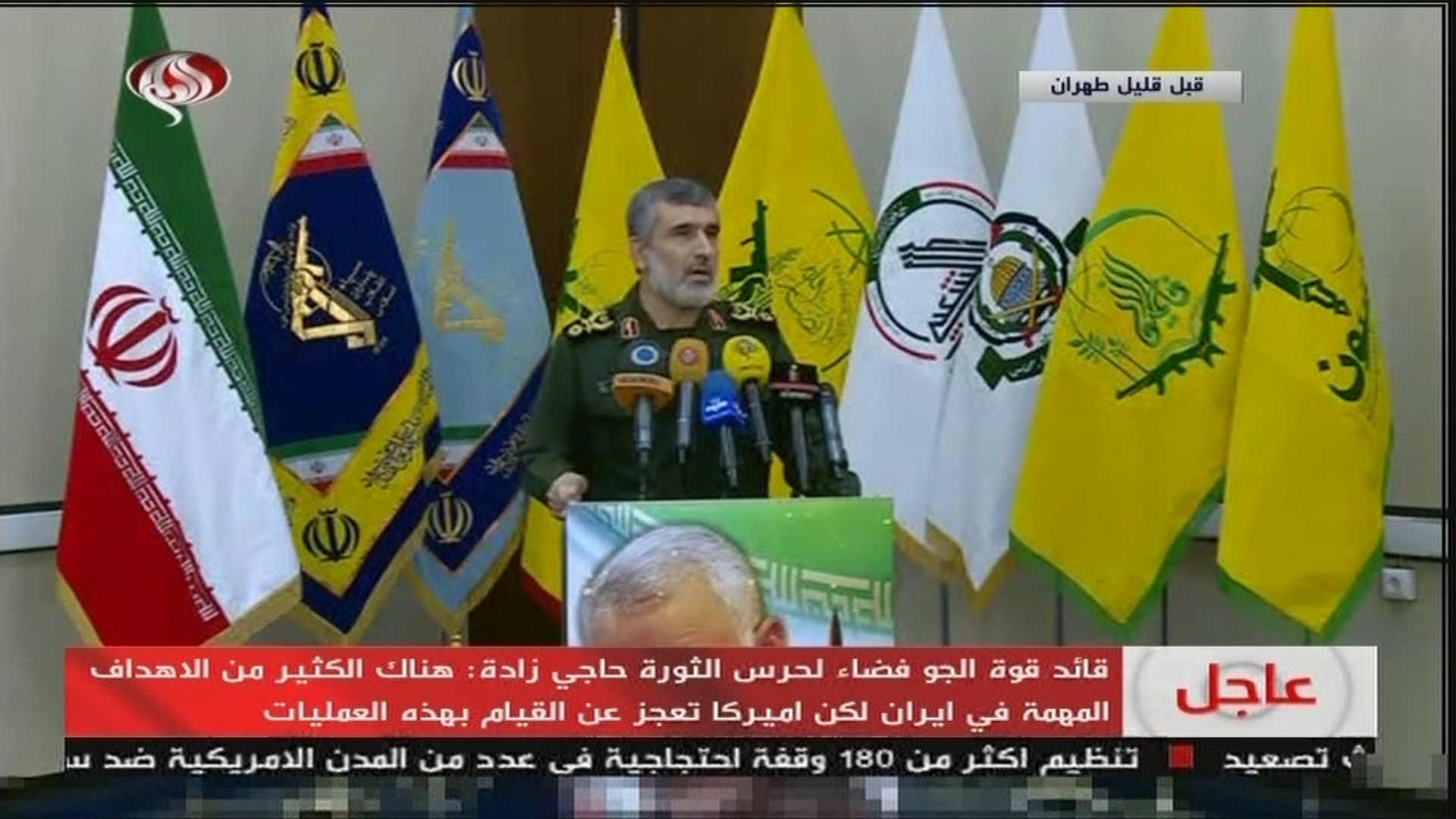 IRGC airforce commander Amir Ali Hajizadeh appears on state TV in front of proxy flags including the PMU militia flag, January 9. (Screengrab from Twitter)