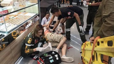 Paramedics helping a man wounded during a robbery at a shopping mall in the town of Lopburi. A masked gunman killed three people including a two-year-old child and wounded four. (Photo: AFP)